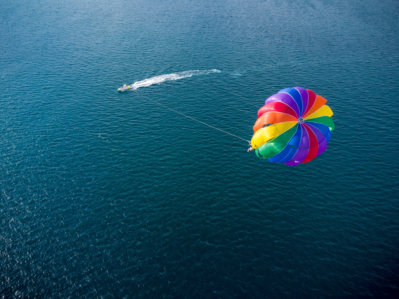 Aerial top view of the boat and parachute in the sea resort